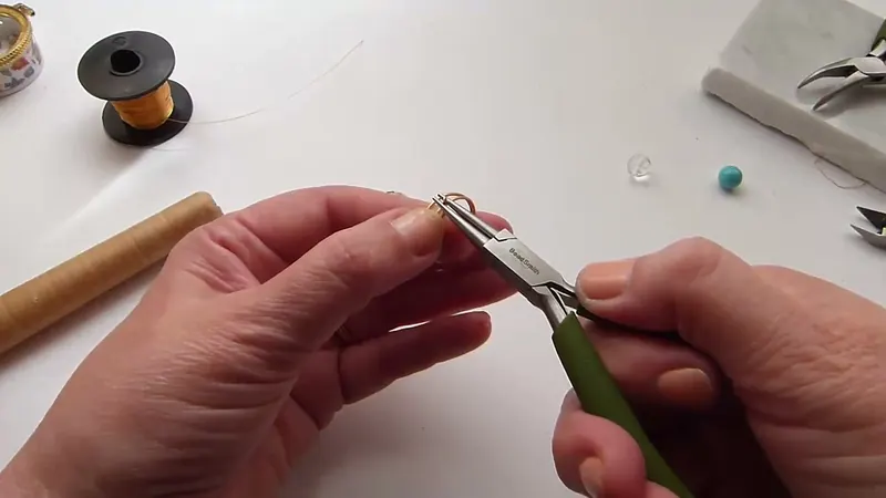 Pinza de punta plana que levanta el alambre para formar el aro tope