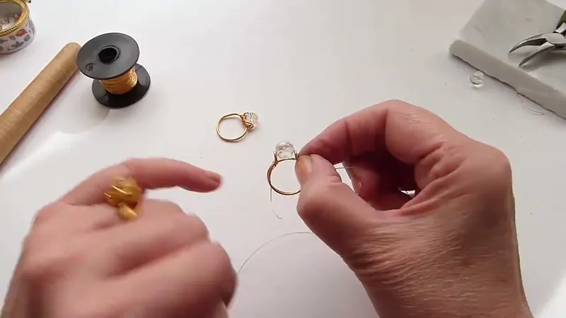 Manos que sostienen el cristal transparente sobre la base del anillo