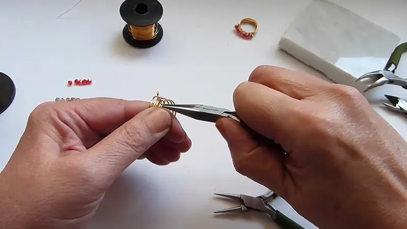 Pinza de punta plana que gira uno de los aros de la banda de alambre