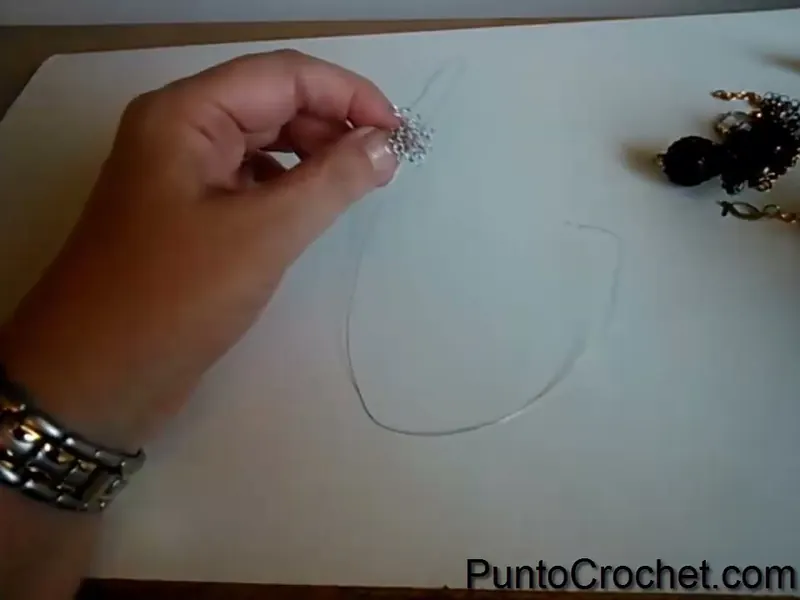 La rueda de ocho puntos de alambre sostenida en la punta de los dedos