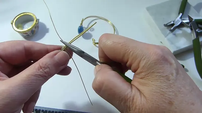 Pinza de punta redonda que ajusta las vueltas de una tira fina en el otro extremo del brazalete