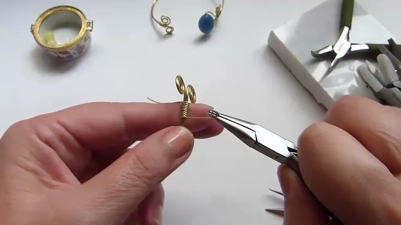 Pinza de punta redonda que cierra un espiral corto en la punta del brazalete