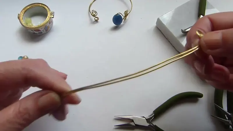 Manos que curvan el brazalete de alambre alrededor de un recipiente redondo