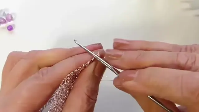 Aguja de crochet trabajando la cadeneta en el borde de la malla plana
