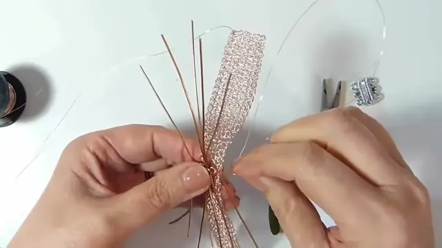 Tiras de alambre de oro rosa abiertas sobre la malla, sujetas con alambre delgado, con las manos y una pinza
