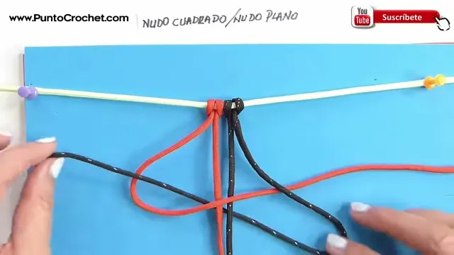 Los cordones rojos y negros colgados de la soga base, con un cordón formando el 4 para el nudo cuadrado