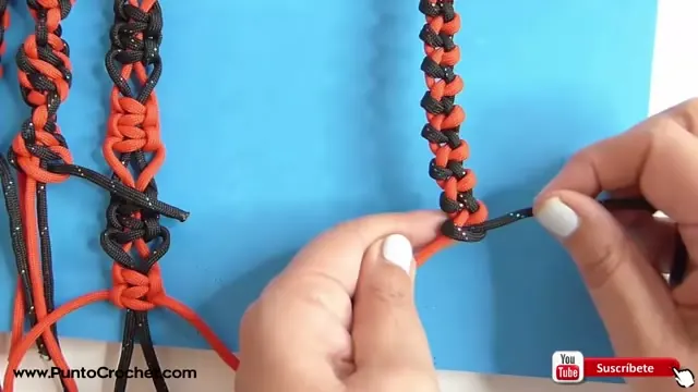 Columna de festón rojo y negro con una mano ajustando el nudo en la parte de abajo