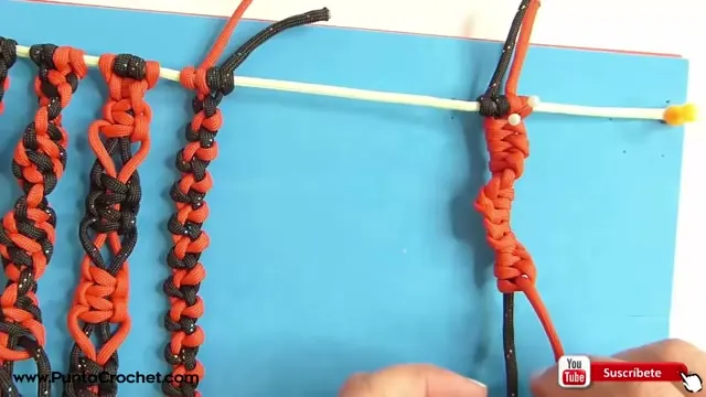 Columna roja con el giro del festón en espiral y las manos ajustando el último nudo