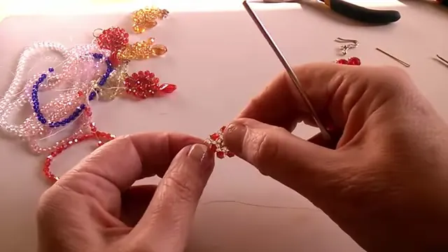 Pieza con los seis primeros cristales rojos incorporados, sostenida entre los dedos