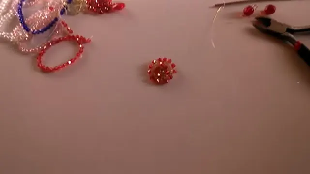 Aro tejido y terminado sobre la mesa, con la pinza de corte al lado