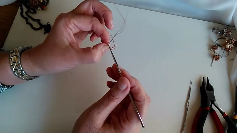 Aro pequeño de alambre cerrado en la aguja de crochet, sostenido con los dedos