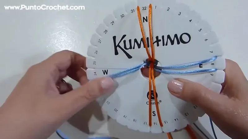 Disco kumihimo con ocho hilos celestes y naranjas en cuatro pares, listo para empezar la trenza