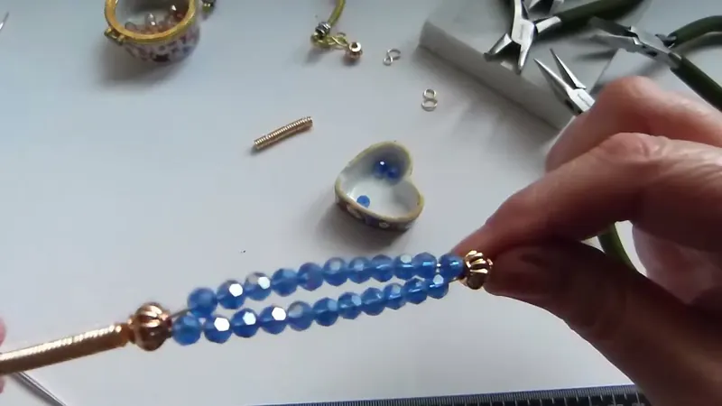 Dos filas de cristales azules entre dos terminales doradas, con el resorte a un lado