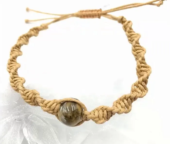 Pulsera de nudo espiral en cordón beige con una gema marrón en el centro y un cierre de nudo corredizo