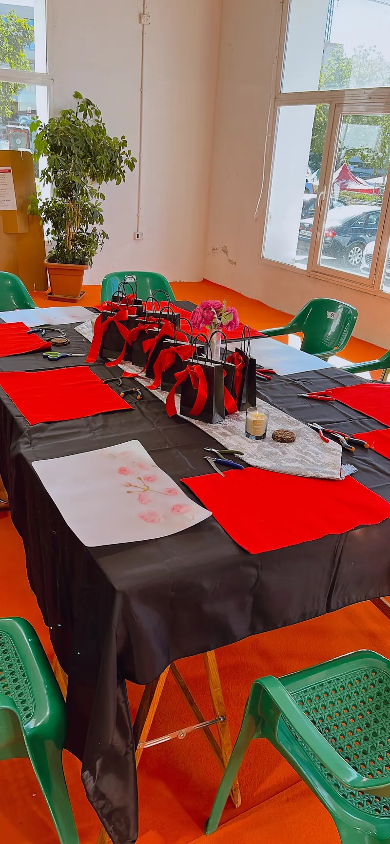 Mesa preparada para una clase participativa en Cuenca, con fieltros rojos, alicates y bolsitas con lazo